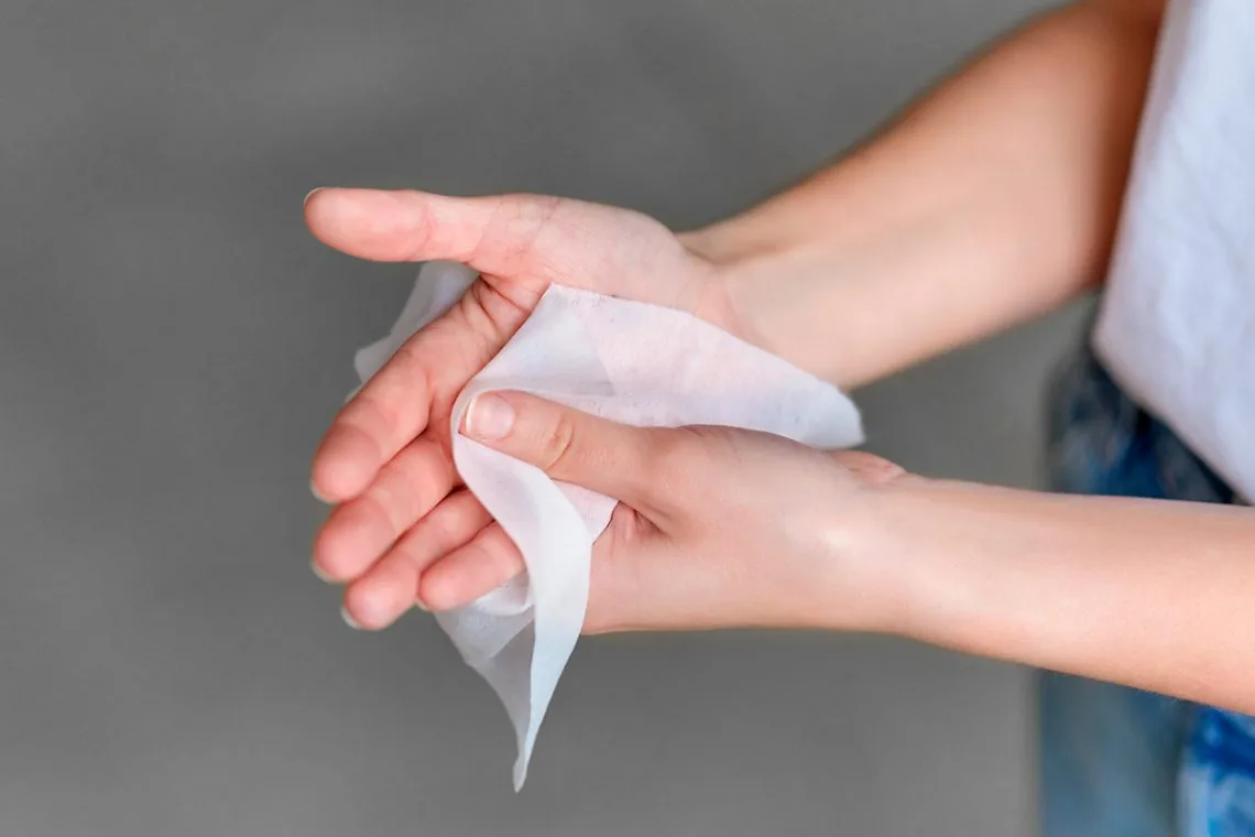 Manos secándose con una toallita, tratamiento para la hiperhidrosis.